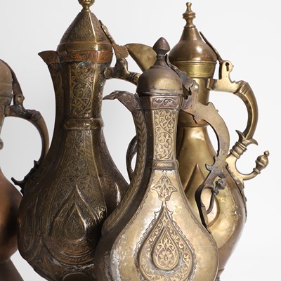 Lot 24 - A collection of four copper and brass ewers