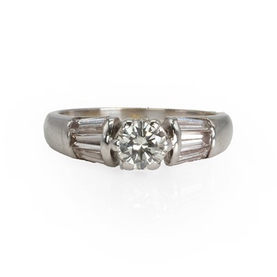 Lot 68 - A diamond single stone ring with baguette diamond shoulders