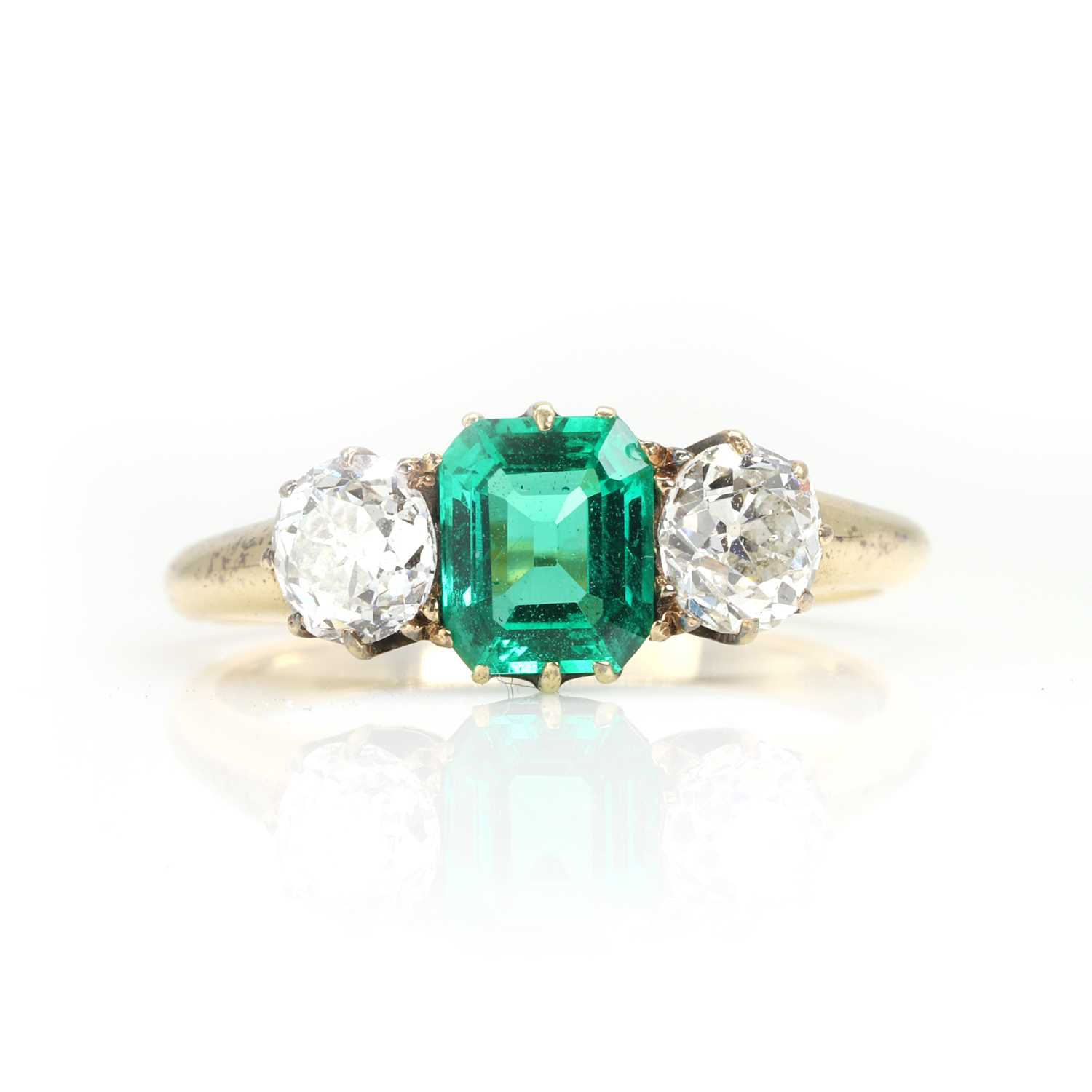 Lot 250 - An emerald and old cut diamond three stone ring
