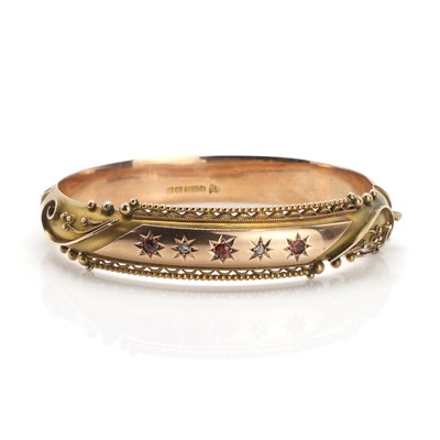 Lot 26 - An Edwardian 9ct gold garnet and rose cut diamond set hinged bangle