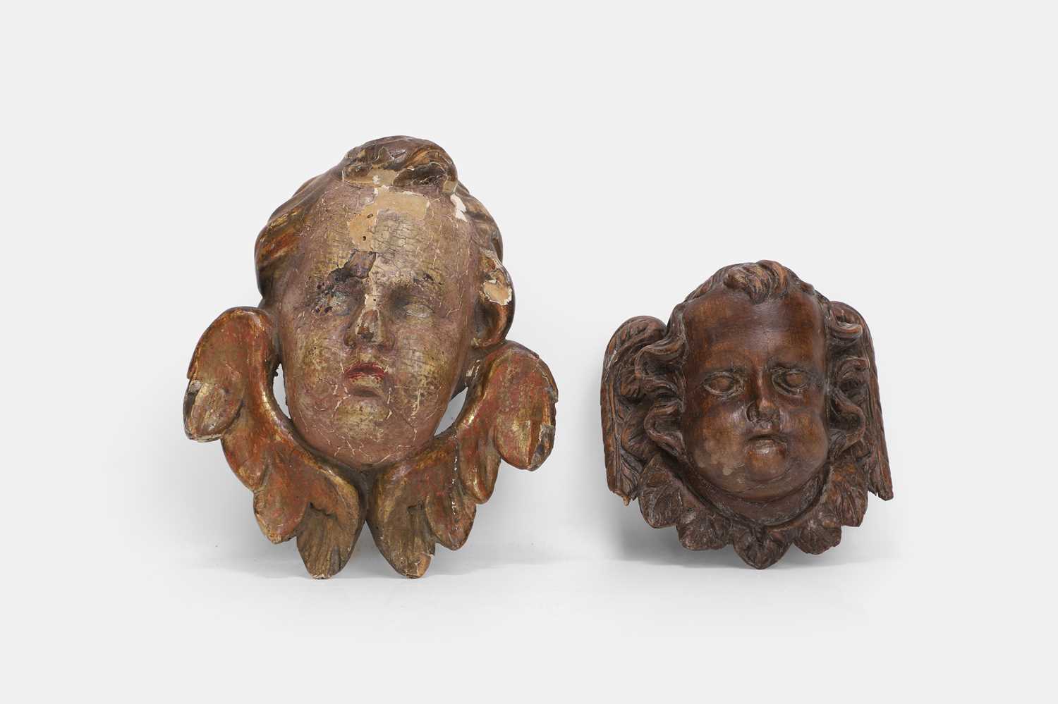 Lot 100 - Two carved wood putti heads