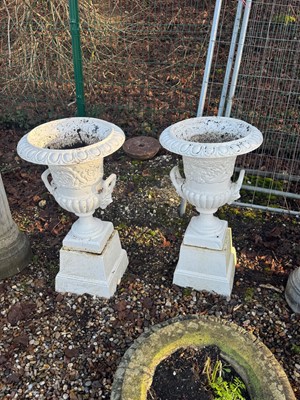 Lot 562 - A pair of cast iron garden urns and stands