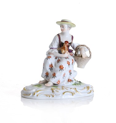Lot 147 - A Meissen figure of a seated lady with a hen and basket of eggs