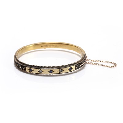 Lot 23 - An Edwardian 15ct gold diamond and sapphire hinged bangle
