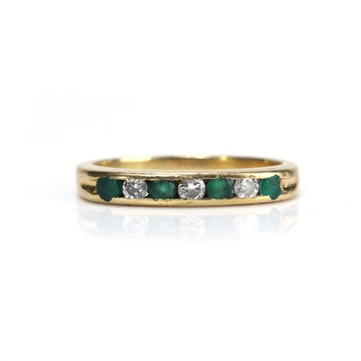 Lot 190 - An 18ct gold emerald and diamond half eternity ring