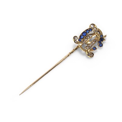 Lot 39 - An Edwardian diamond and blue paste set monogram stick pin
