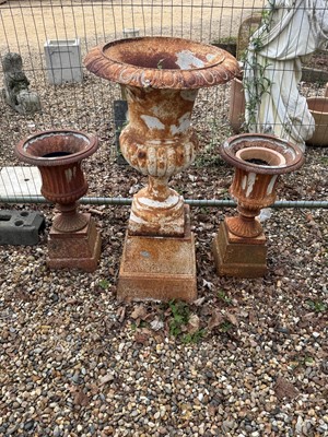 Lot 554 - A large cast iron urn, and a pair of smaller garden urns