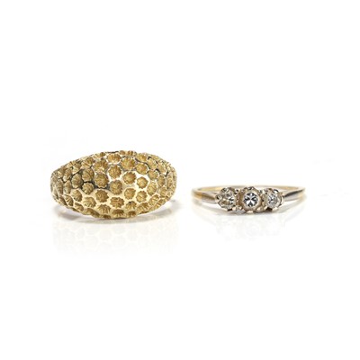 Lot 194 - A gold bombé ring and a three stone diamond ring