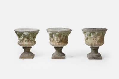 Lot 659 - A set of three composite garden urns