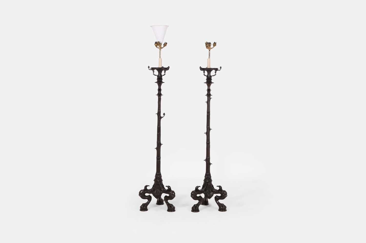 Lot 57 - A pair of patinated bronze floor lamps