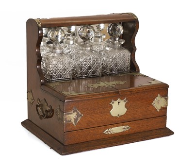 Lot 313 - A oak and silver plated three bottles tantalus