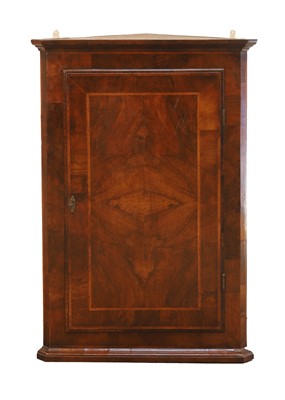 Lot 517 - A George II walnut featherbanded corner cupboard
