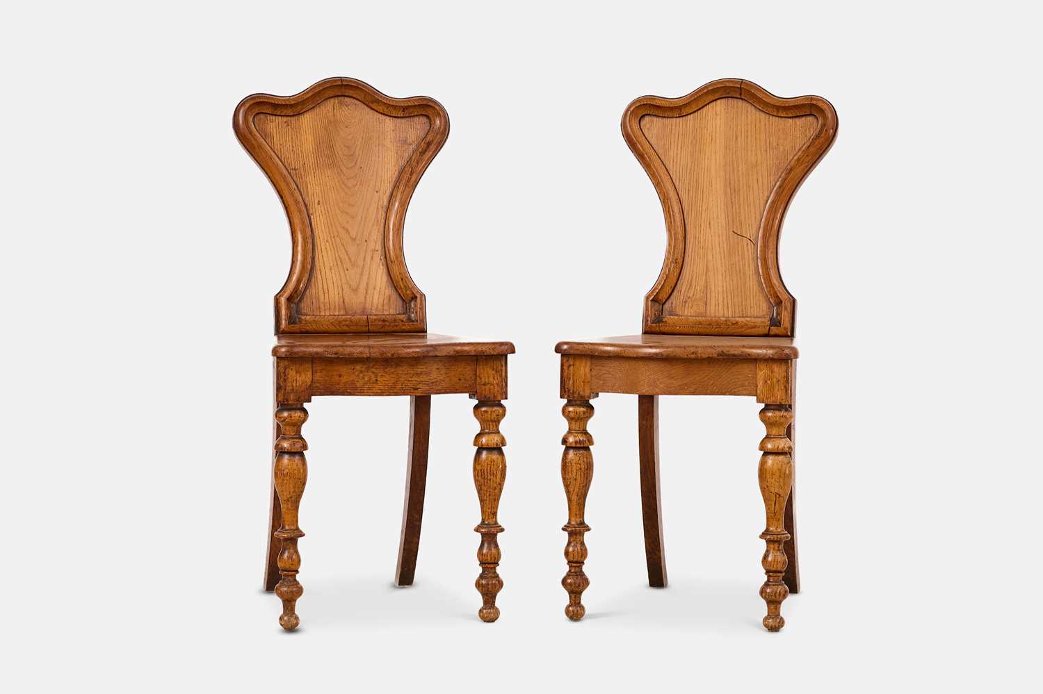 Lot 235 - A pair of golden oak hall chairs
