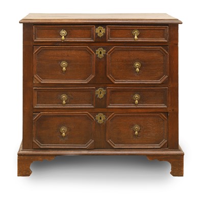 Lot 526 - An oak geometric mould chest of four drawers